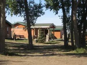 Cabins and park buildings at Killdeer Mountain Park surrounded by trees and a quiet rural setting