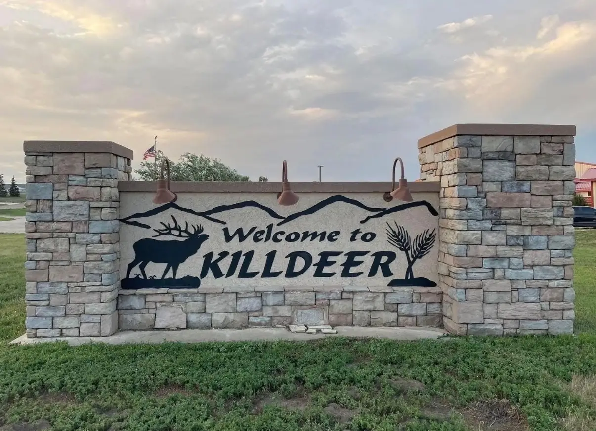 Welcome sign for Killdeer, North Dakota, featuring stonework and wildlife imagery